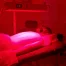 Side view of red light therapy session using medical-grade LED panel.